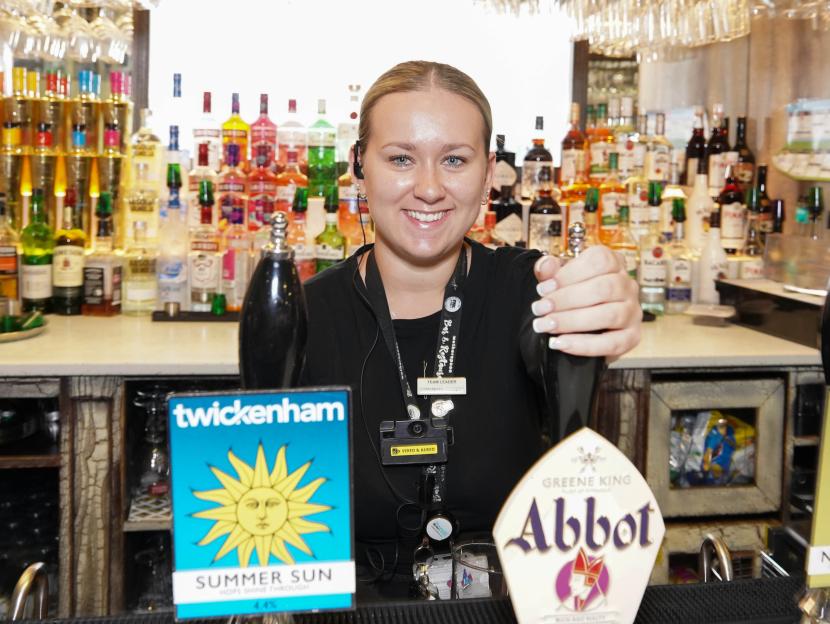 A bartender at a pub pours a drink.