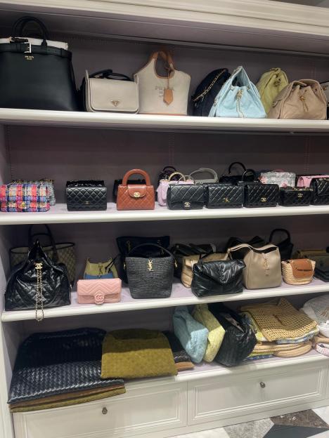 A closet filled with a large collection of designer handbags.