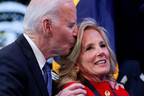 President Biden kissing First Lady Jill Biden on the forehead at a ceremony.