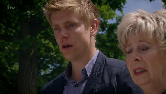 Still image from Emmerdale showing Robert Sugden and another character.