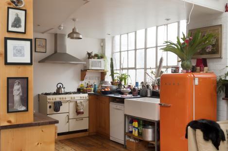 Orange retro Smeg fridge in a kitchen.