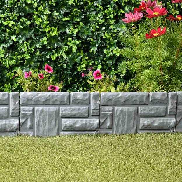 Stone effect garden edging in front of flowers and greenery.