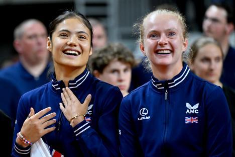 Two smiling members of Great Britain's Billie Jean King Cup team during the national anthem.