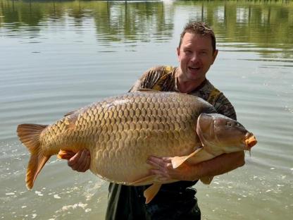 Angler holding a large carp weighing 105.4 lbs.