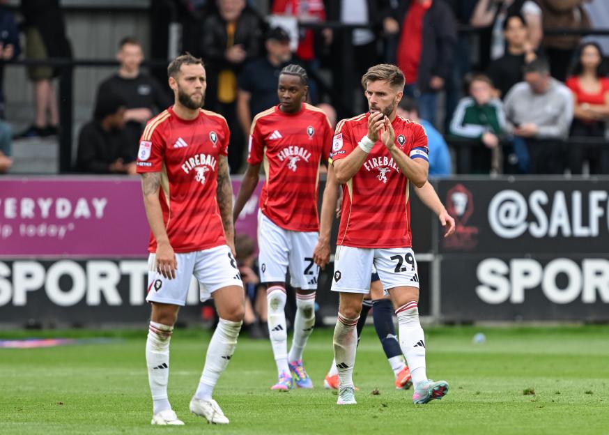 Salford City players react to conceding a goal.