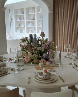 Table set for a meal with a large floral centerpiece.