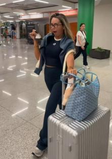 Samantha Kenny at an airport, holding a boarding pass.