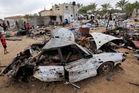 Damage to a car and surrounding structures at a displaced persons camp in Khan Younis, Gaza.
