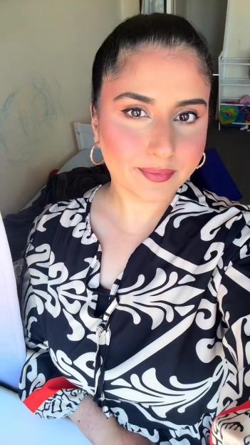 Woman in black and white patterned blouse.