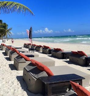 Beach lounge chairs on a white sand beach.