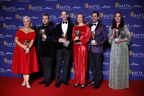 EastEnders cast and crew holding BAFTA awards.