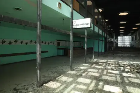 Interior of an abandoned cafe with a sign that reads