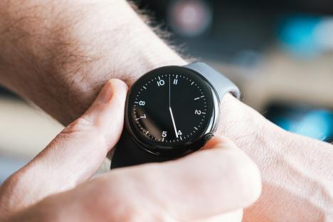 Close-up of a man adjusting a smartwatch on his wrist.
