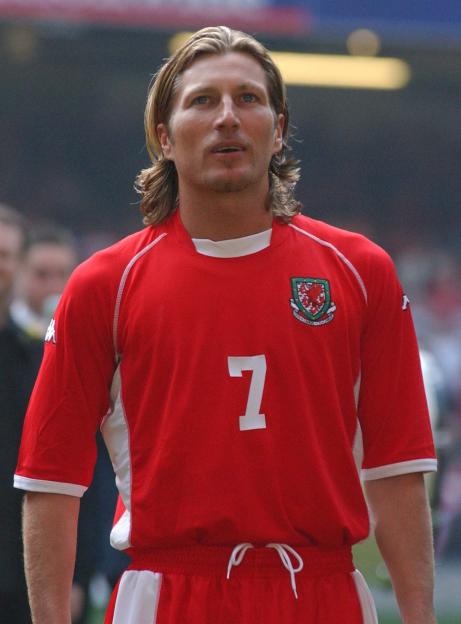 Robbie Savage wearing a red Wales football jersey with the number 7.