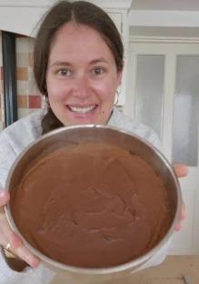 Woman holding a pan of chocolate cake batter.
