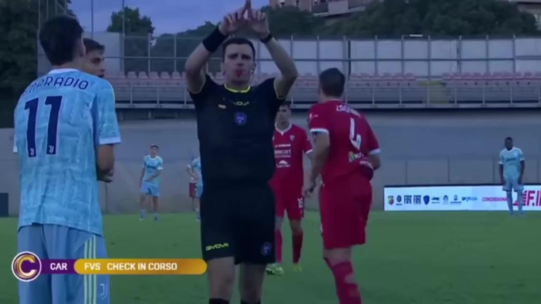 Referee signaling a foul during a soccer game.