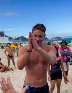 British tourist Jensen Sturgeond thanking rescuers on Copacabana Beach in Brazil after being rescued from the sand.