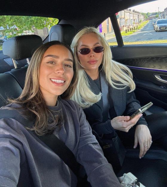 Two women sitting in the backseat of a car.