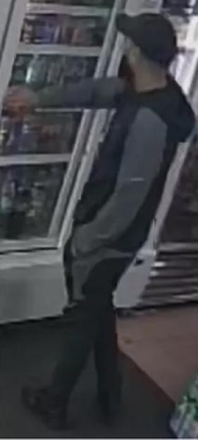CCTV footage of murder suspect Mohammed Maneer Khan reaching into a refrigerated display case.