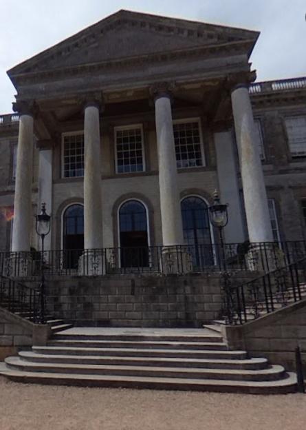 Stone staircase leading to a classical building with columns.