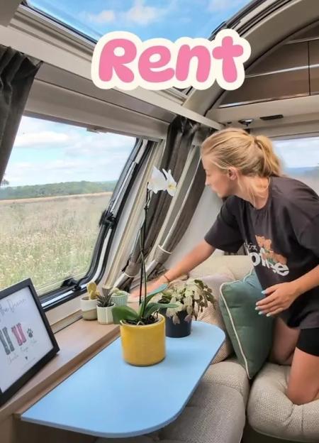 Woman arranging plants on a table in a caravan.