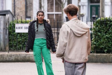 A still from EastEnders showing Avani Nandra-Hart and Joel in Albert Square.