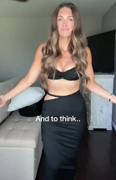 A woman in a black bra and skirt with a cutout at the hip.