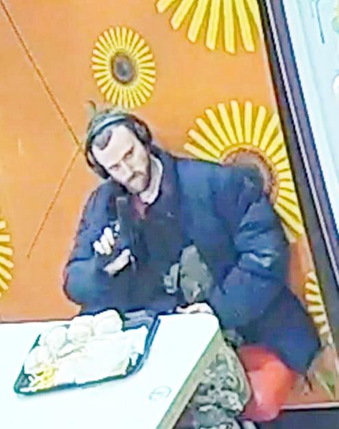 Surveillance image of Jacob Jenkins brandishing a gun in a McDonald's.