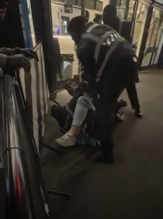 Security guards subduing a person on the ground.