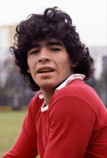 Photo of Diego Maradona in a red Argentinos Juniors shirt.