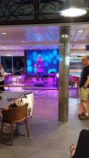 Woman singing on stage in a ferry lounge.