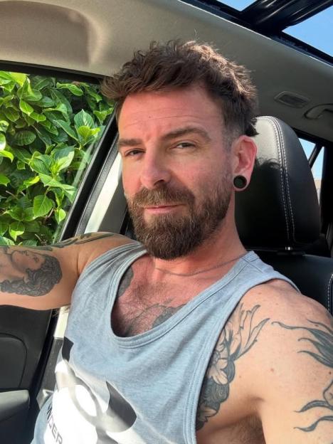 Selfie of a man with tattoos in a car.