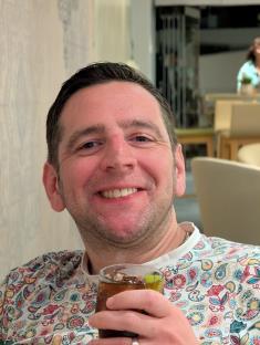 Man smiling and holding a drink.