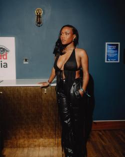 Woman in black leather pants and a black halter top.