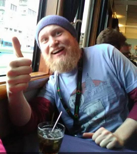 Benjamin Wilcock, with a beard and beanie, giving a thumbs up.