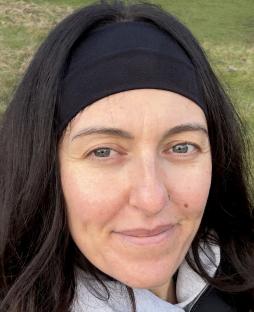 Close-up of a woman with long dark hair and a black headband.