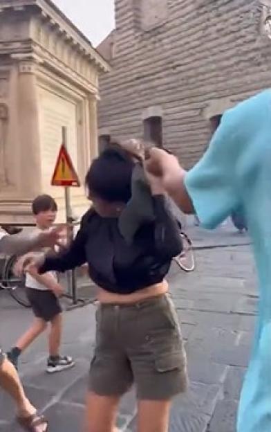 Woman adjusting her hair on a city street.