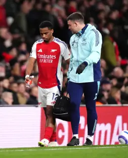 Arsenal's Jurrien Timber leaves the pitch with a medical staff member.