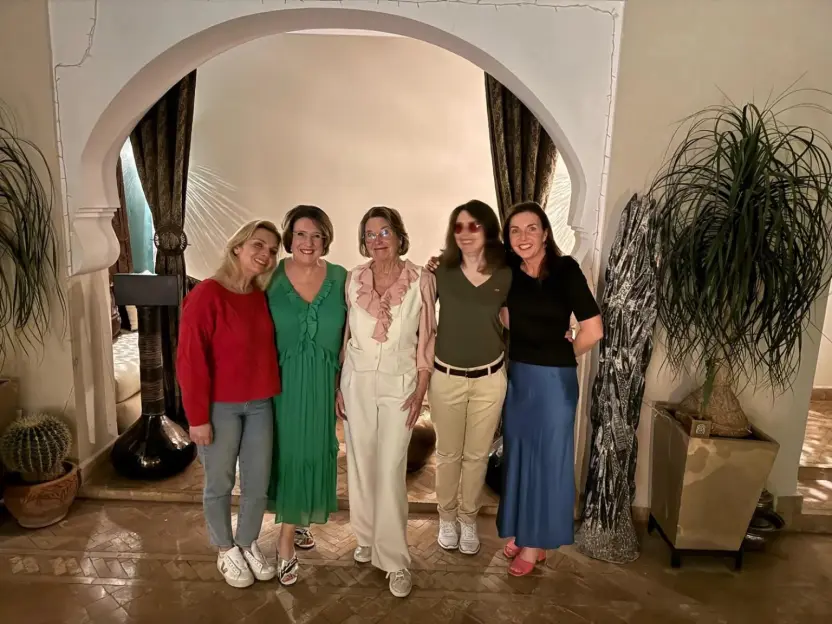 Five women pose for a photo in a Moroccan-style room.