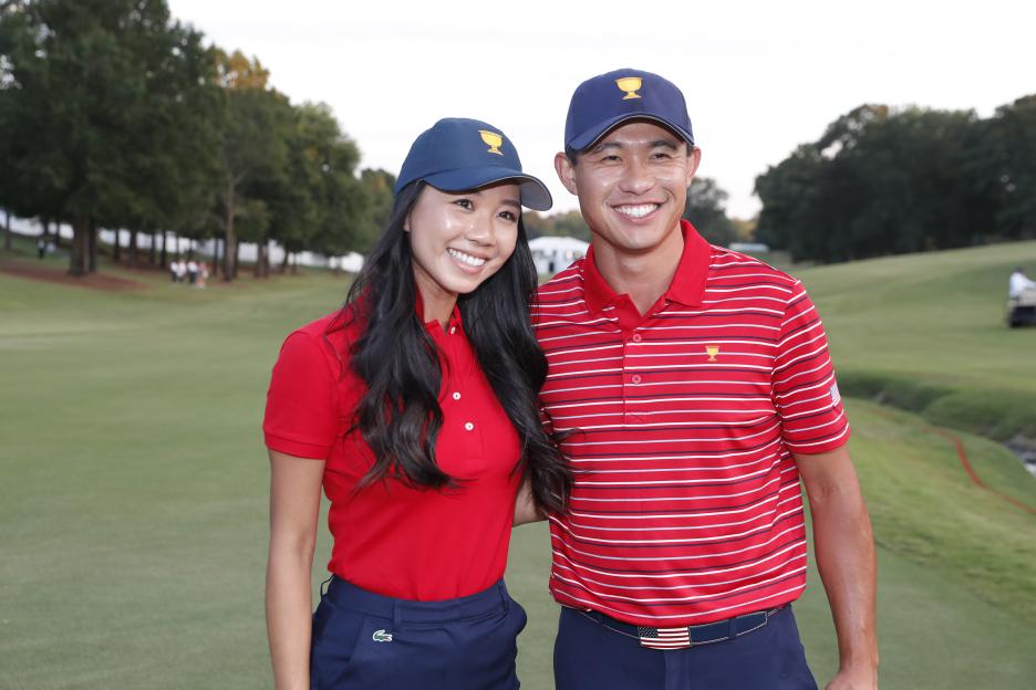 Collin Morikawa and his girlfriend Katherine Zhu in Presidents Cup hats and matching red shirts after Team USA won.