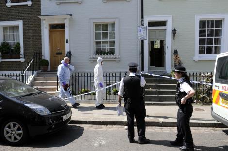 Police officers and forensic investigators at a crime scene.