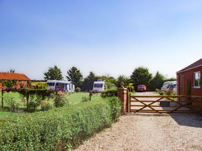 Campsite with caravans and a red car.