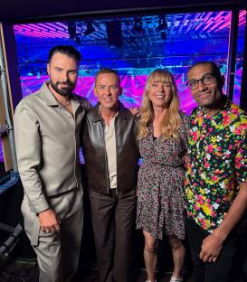 Group photo of four people backstage.