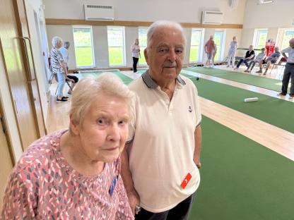Older couple at an indoor bowling green.