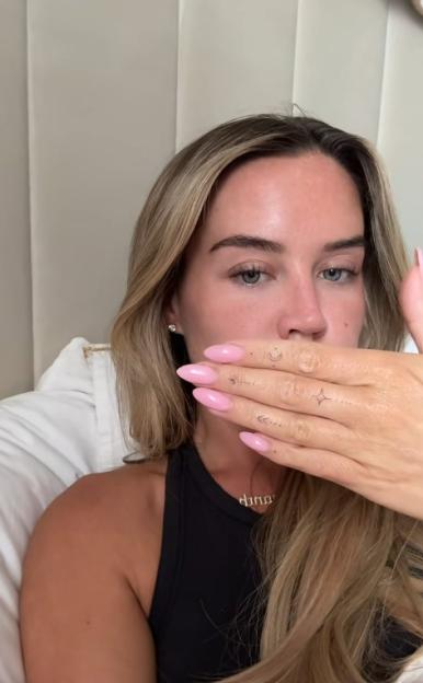 Woman showing small hand tattoos.