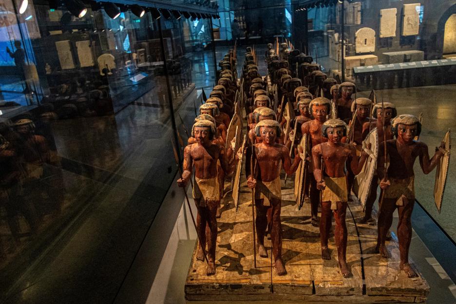 A display of ancient Egyptian soldier figurines in a museum exhibit.