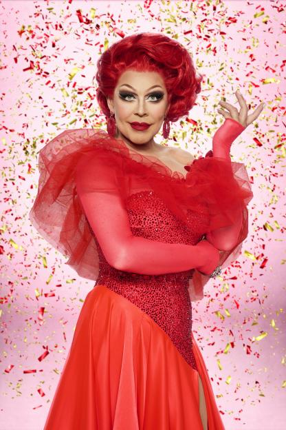 La Voix in a red gown with a red wig, red gloves, and red earrings.
