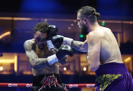 Liam Cameron punches Ben Whittaker during a light heavyweight boxing match.