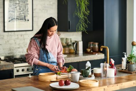 Woman chopping vegetables in a kitchen.