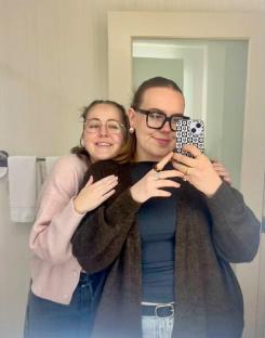Two young women hugging and taking a selfie.
